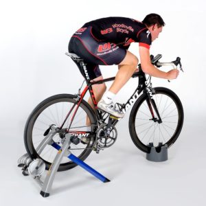 man riding bike that is locked on stationary bike stand