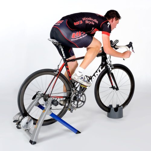 man riding bike that is locked on stationary bike stand